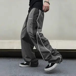 Men’s black color-block athletic pants featuring white stripes and embroidered details along the sides; loose-fit polyester long pants with a drawstring and straight leg, suitable for fitness and everyday casual streetwear — men’s trousers
