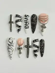 Luxury Gothic Y2K Stiletto Press-On Nails in White and Nude with Black Lace Design, 3D “SWAG” Lettering, Silver Cross Charms, Chain Details and Rhinestone Embellishments – Bold Street Style Statement Nail Set
