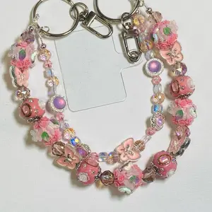 Handcrafted keychain/phone charm/ bagcharm, fancy beads with glass Crystal ascents to make this keychain stand out it. Butterfly charms ro enhance the beauty, double split rings with hooks to attach to purse or bag.  Phone card attachment included