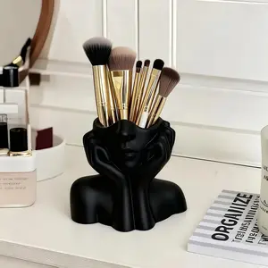 A Cute Makeup Brush Storage Box Shaped Like a Human Face, Featuring a Minimalist White Design That Captures The Relaxed Vibe of a Resting Face. This Artistic Piece for Your Desk Combines Practicality with Aesthetic Appeal