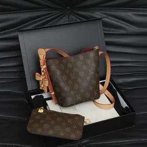 Bucket bag with gold-tone lock charm and detachable coin purse, classic printed crossbody bag for women, featuring red stitching, plush lining, adjustable shoulder strap, and top handle; a versatile bag perfect for commuting.fashionable