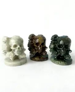 sculpture featuring roses made of different materials blooming from the skull.