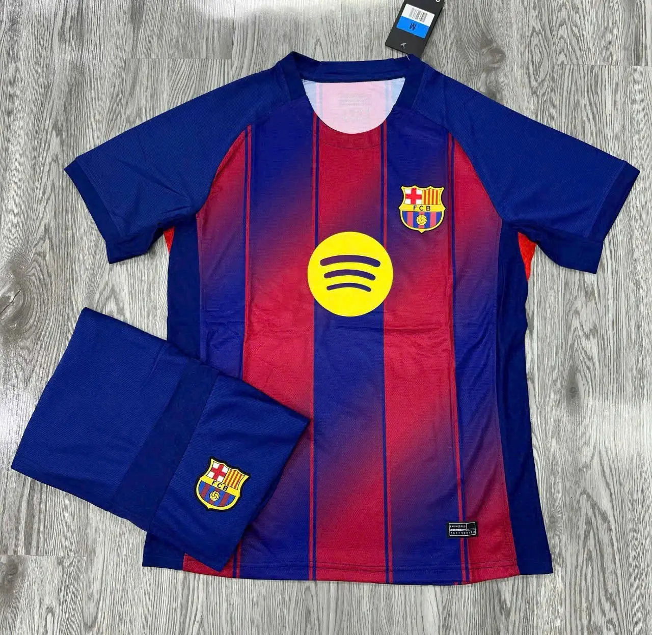 Barcelona 25/26 Home Soccer Jersey (Free Matching Shorts Included) Wood Floor Flat Lay Display | Blue Red Gradient Vertical Stripes Football Kit | La Liga Fan Gift
