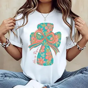 Vivid Cross and Bow Design Cotton Short Sleeve Casual T Shirt Featuring He Is Risen Graphic for Easter Seasonal Christian Wear Machine Washable Not Dry Cleanable Made in Usa