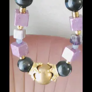 Pressure: 20mm Crystal Spheralite purple UV Reactive Aura Cube , 35mm blue tiger eye, 40mm gold pyrite sphere as the center piece, adding in gold colored crowns and 25mm red wood spheres creates this outstanding powerhouse of a necklace?