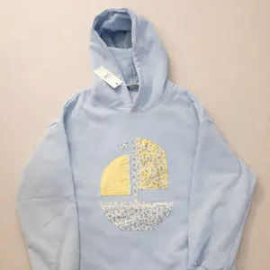 Light Blue Size Medium Women's Oversized Hoodie with Floral Yellow Sailboat Patchwork Design