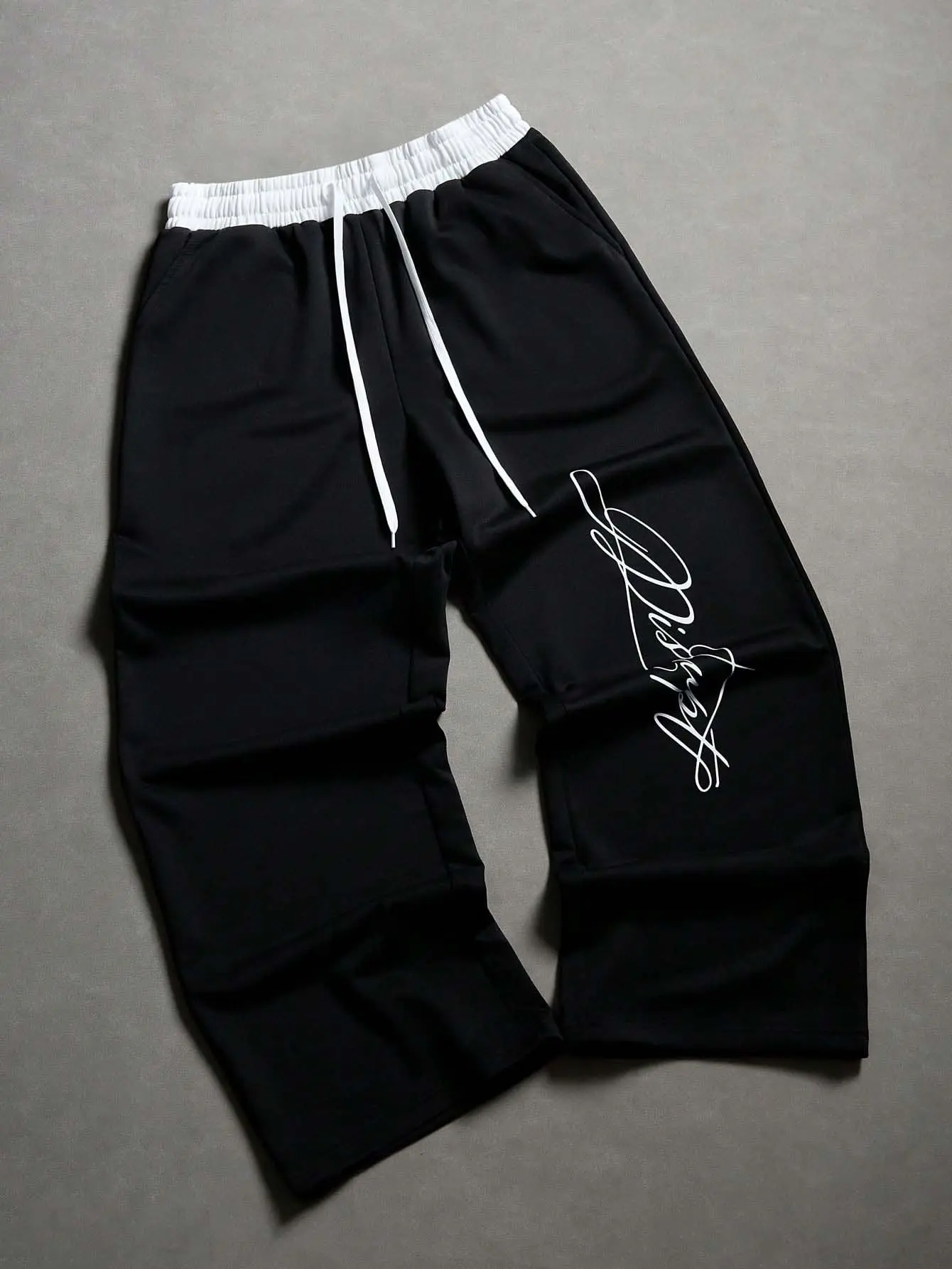Unisex wide leg sweatpants with a white contrast waistband and handwritten script print — double layer elastic waist, matching drawstring, smooth drapey knit, available in multiple colors; American retro high street pants for gym and street.