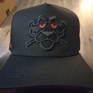 Gorra panter bordada  color obscuro  visera roja por debajo