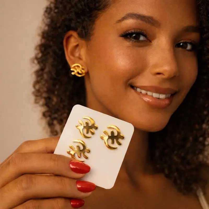Gye Nyame Elegant Gold Earrings Refined gold-tone fashion earrings featuring a polished metal finish and presented in clear, protective packaging. Designed for timeless elegance and everyday wear.
