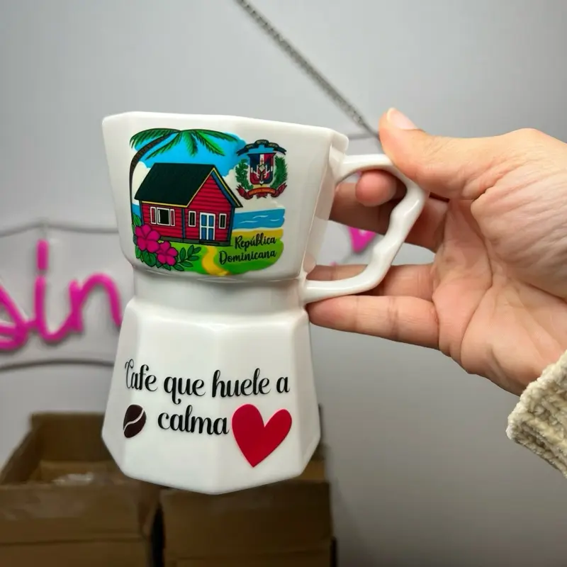 12-ounce coffee mug in the style of a coffee maker, with a Dominican Republic design and the phrase "cafe que huele a calma."