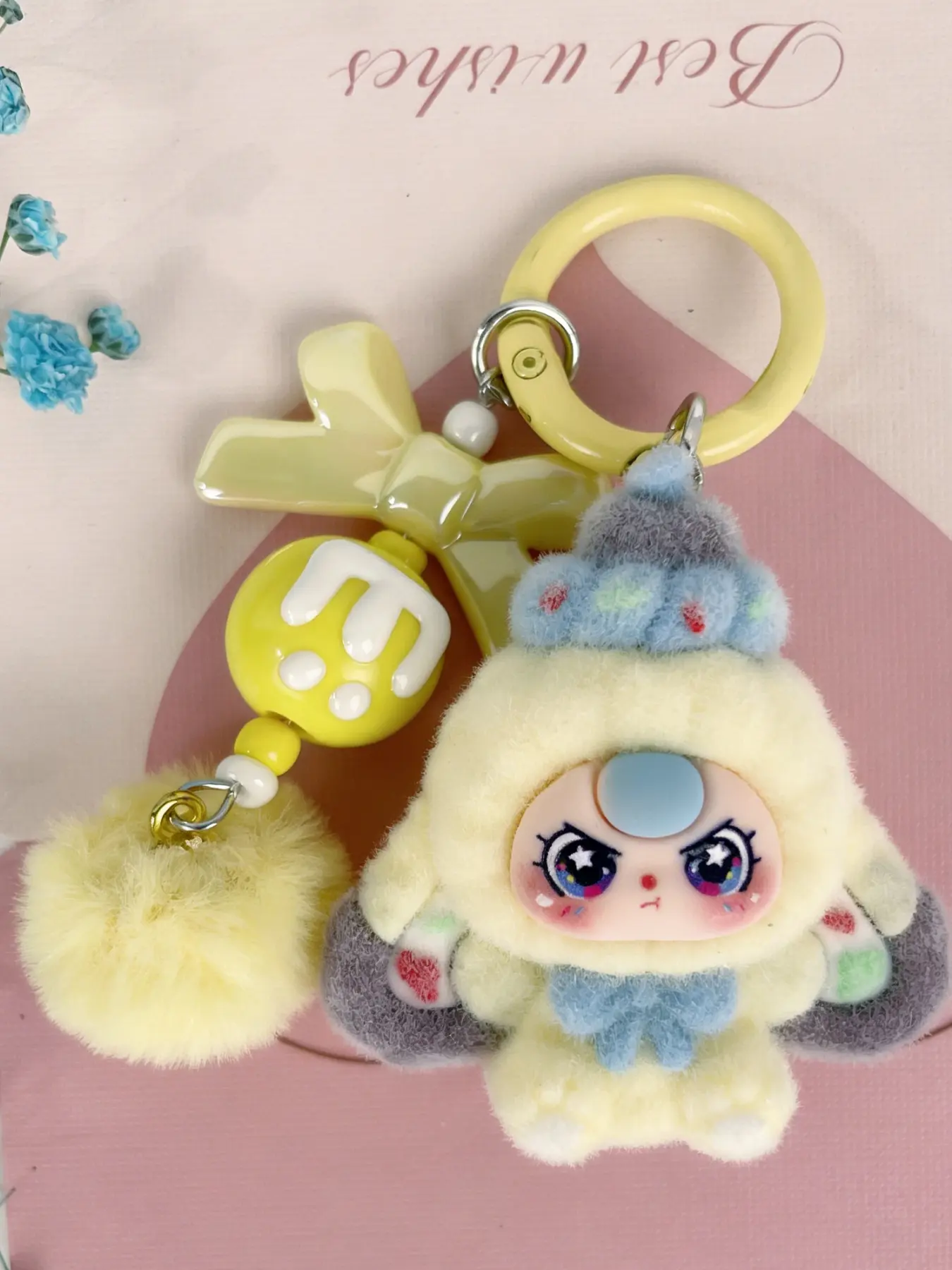 A cute pendant, Cute keychain, Keychain Kawaii, featuring multi-colored plush doll, paired with bow and pom-pom, sweet dreamy style, suitable for hanging on bags or keys, adding girlish lively atmosphere to everyday outings
